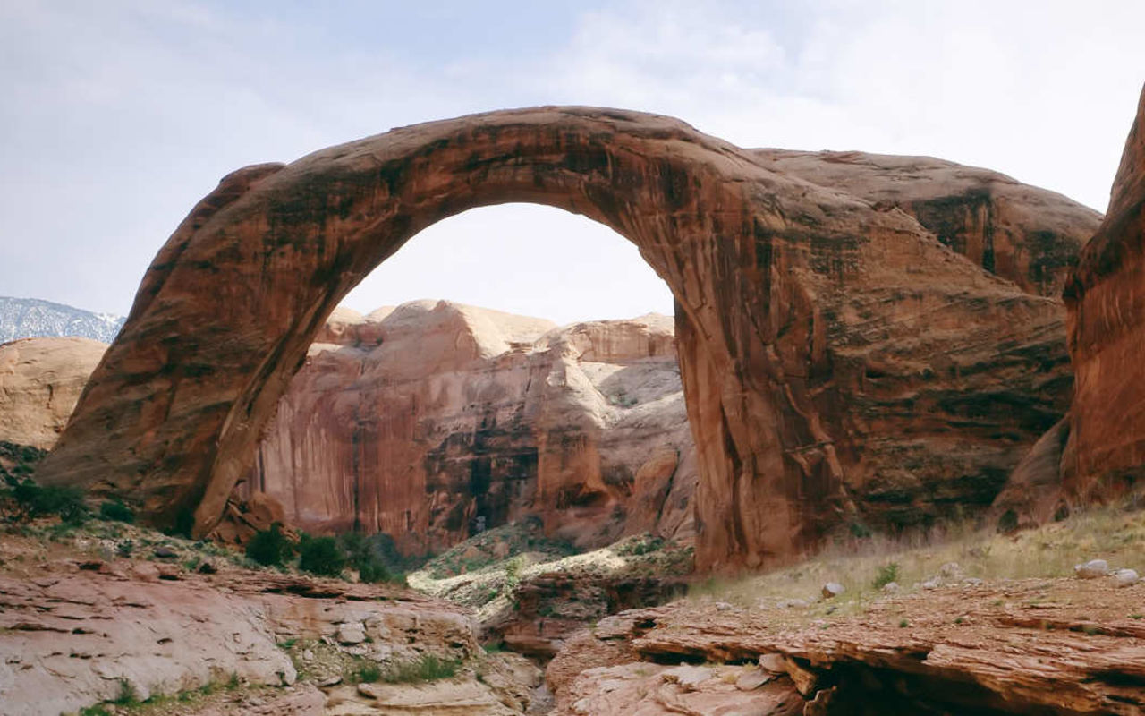 Rainbow Bridge | Photo Gallery | 1 - Rainbow Bridge, on the edge of Lake Powell, is the largest natural bridge in the world at 290 feet/88 meters tall and 270 feet/83 meters across. Rainbow Bridge is considered sacred by the Navajo culture as a symbol of deities responsible for creating clouds, rainbows and rain - the essence of life in the desert.