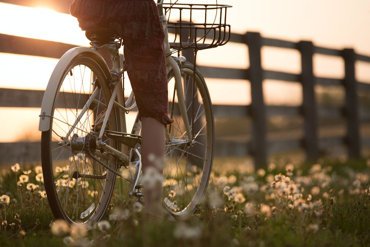 a woman riding a bike through flowers
