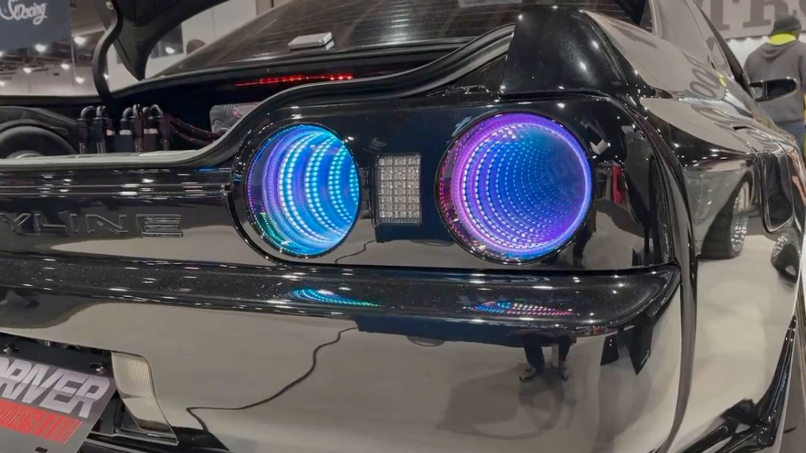 Custom taillights on a Nissan Skyline GT-R 32 appear to spiral into the vehicle, as they illuminate in shades of blue and purple.
