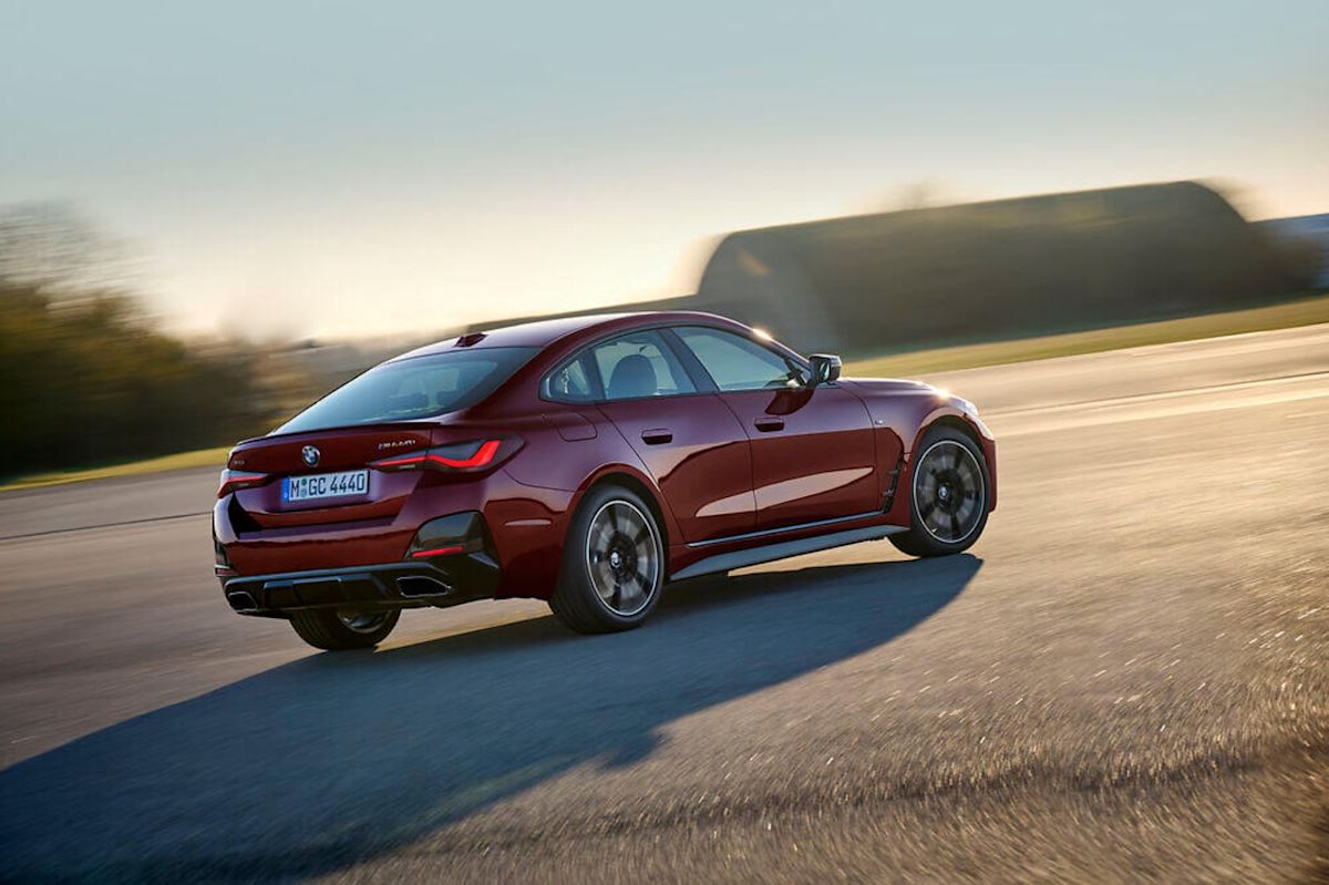 a red 2022 BMW M440i Gran Coup near a green terrain