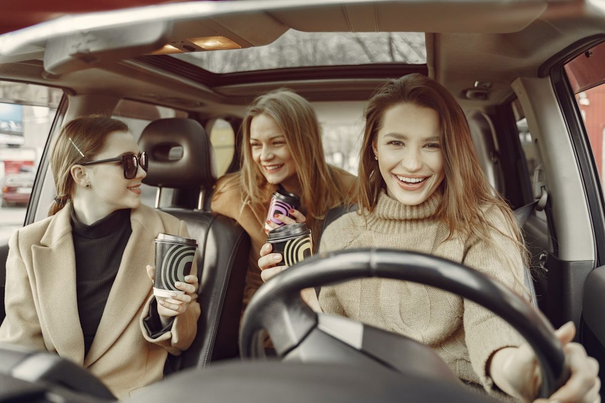 three young women driving in a car