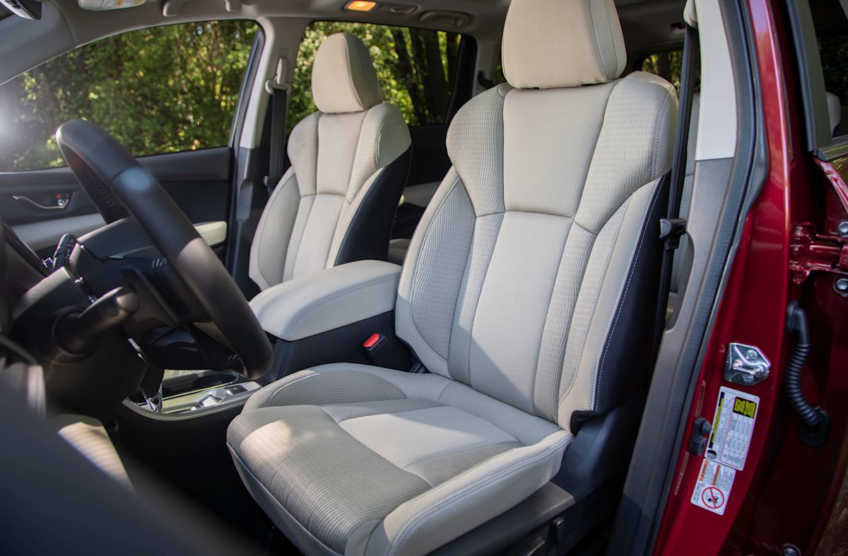 Nappa leather seats shown through the open driver's side door of a red Subaru 