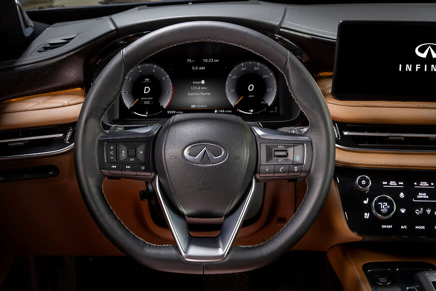 a black wheel and brown dashboard of a 2022 Infiniti QX60.