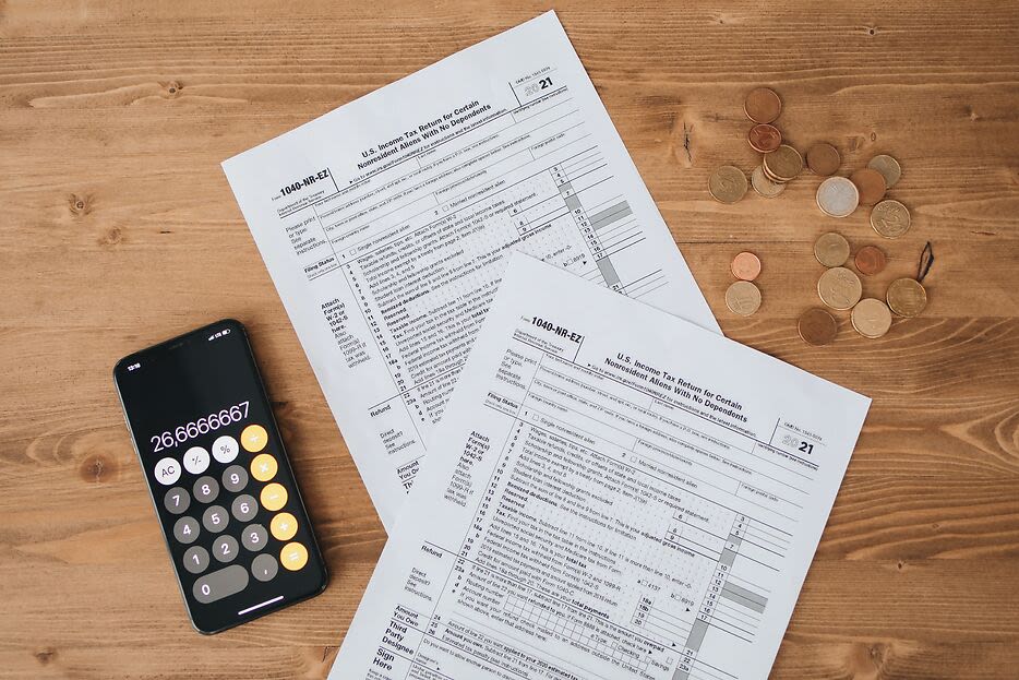 two tax forms next to a calculator