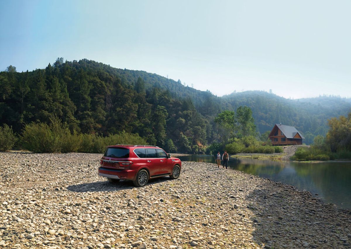 a red Nissan Armada by two people 