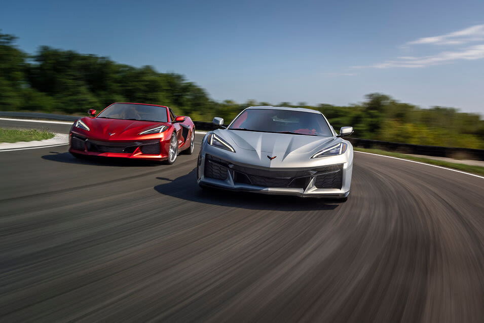 a red and silver 2023 Chevrolet Corvette Z06s driving down a road