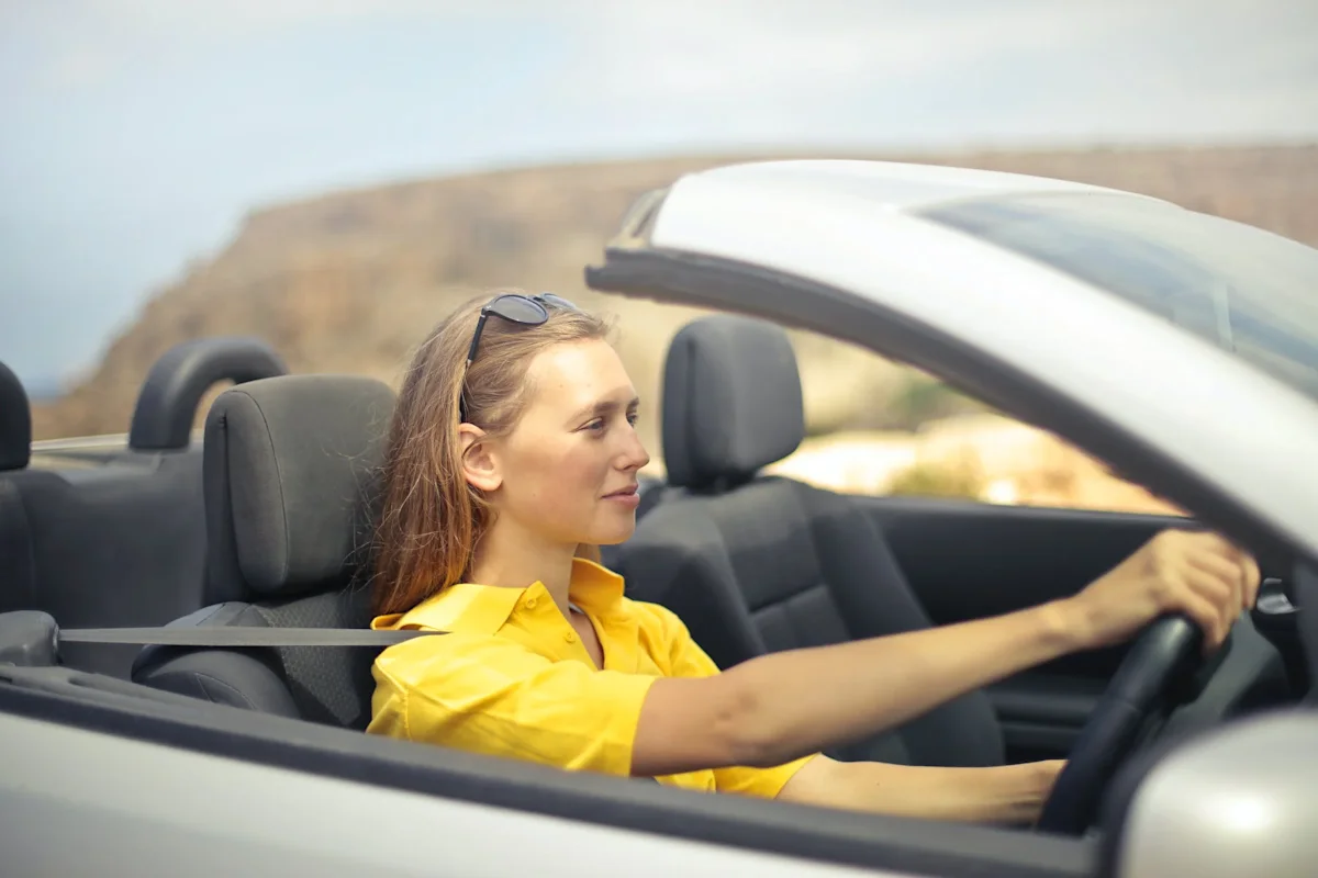 a woman driving a silver car