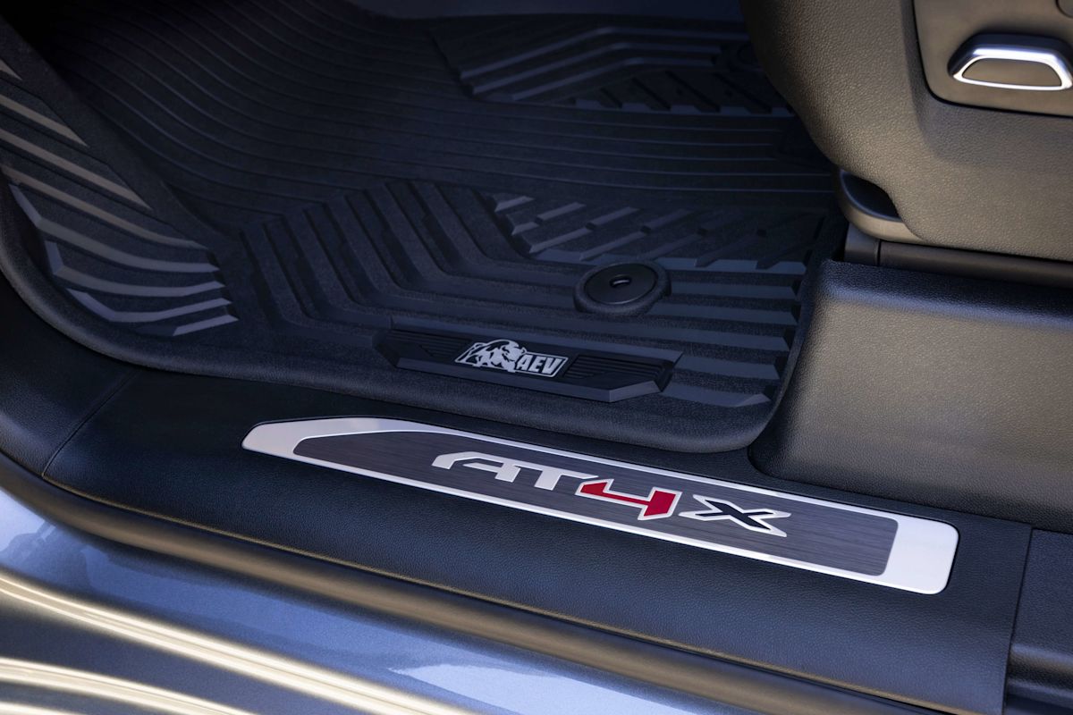 An AT4X nameplate on the top step into a truck. 