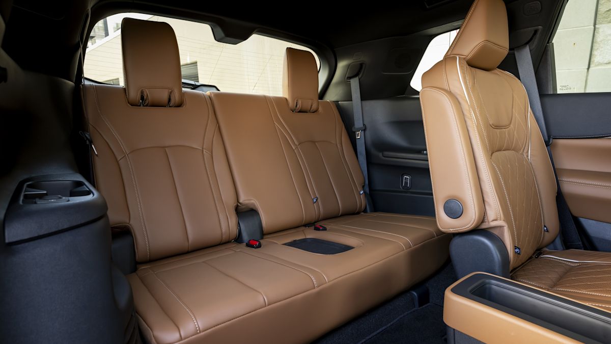 The back rows of the QX60, with three seats of brown leather and black coloring on the doors and accents. 