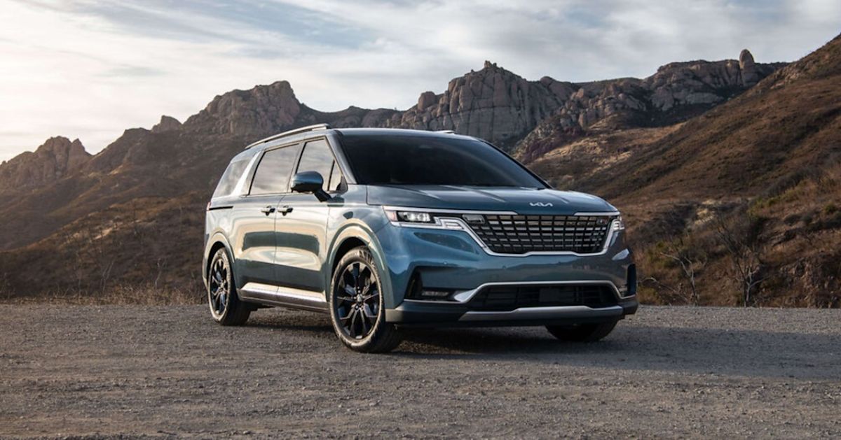 a blue 2022 Kia Carnival standing in front of a canyon.