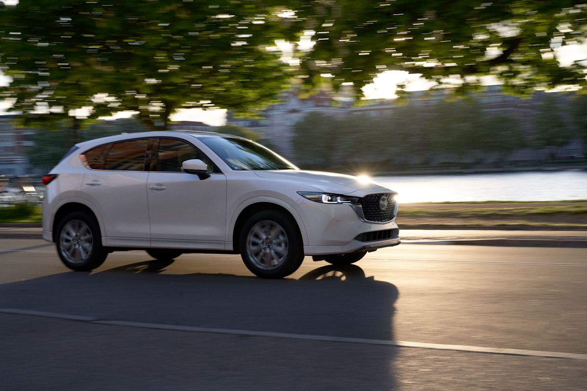 a white 2022 CX-5 2.5 Turbo Signature driving down a road
