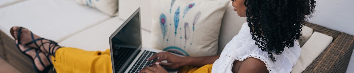 A relaxed woman sitting on her patio with a laptop.
