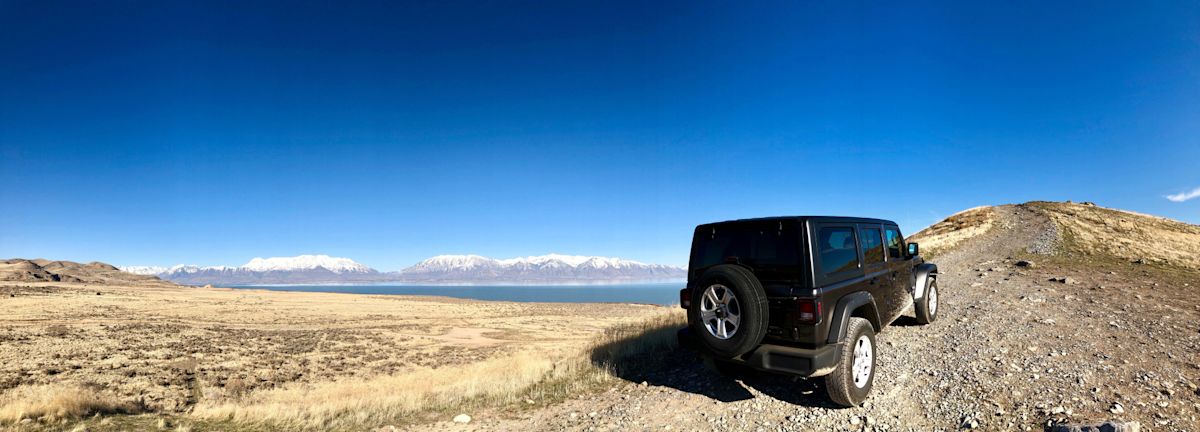 A black Jeep with a hardtop stops on an OHV trail overlooking the Great Salt Lake to enjoy the view