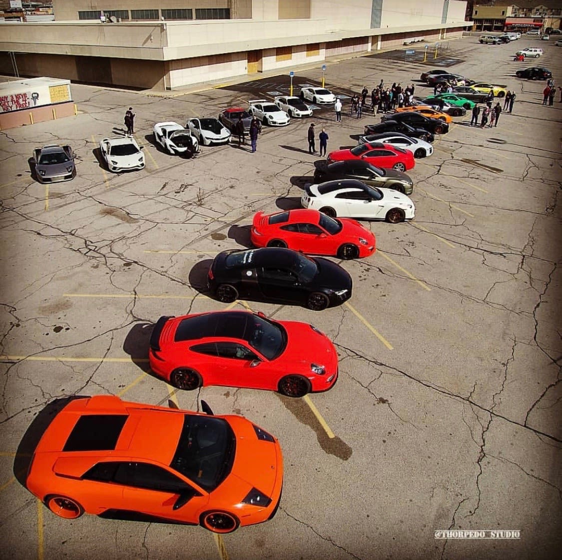 A group of Supercars in the Need II Drive club gather together with their vehicles.