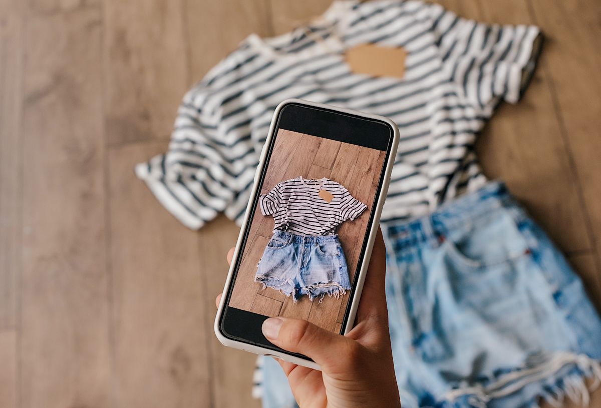 A person taking a picture of some items of clothing, eventually wanting to sell. 