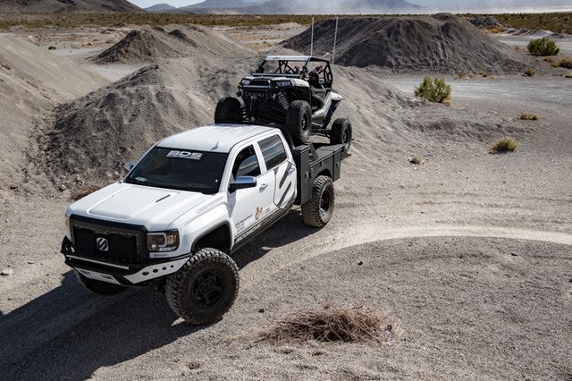 A truck pulling a side-by-side.