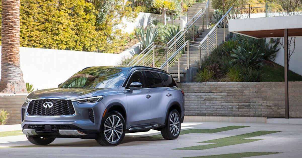 A silver 2022 Infiniti QX60 car parked near a palm tree.