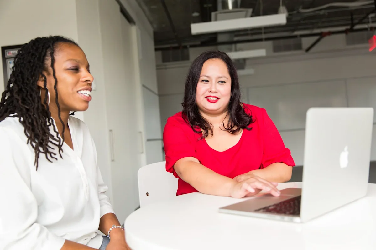 a woman helps another woman in a white shirt finance her car
