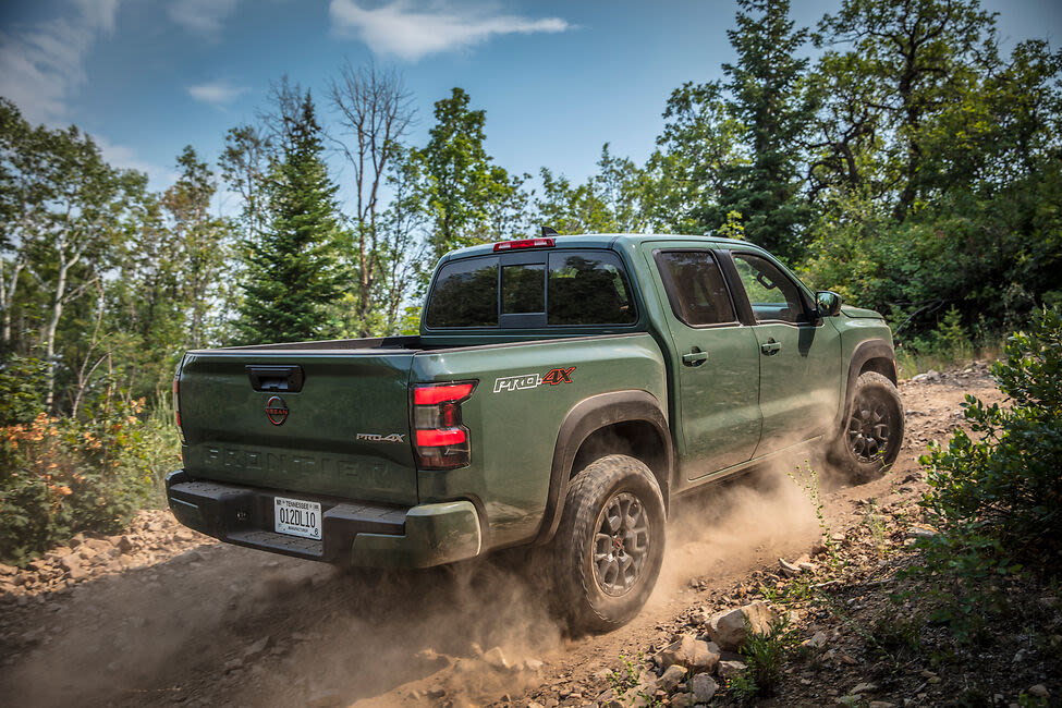 a green 2022 Frontier driving in the dirt