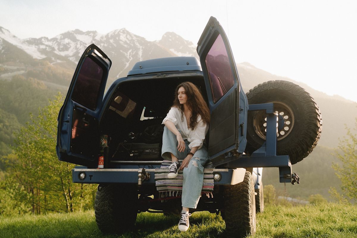 a young woman sitting the back of her truck