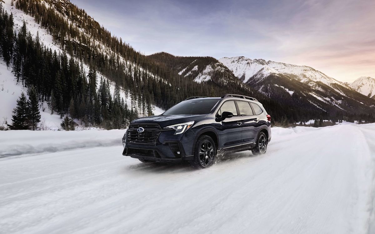 A 2024 Subaru Ascent drives on a snowy mountain road 