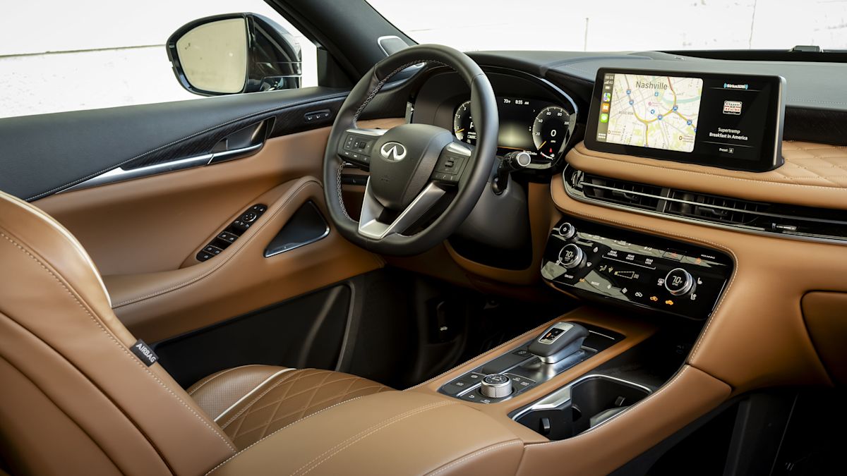 The interior of the QX60, featuring brown and black leather and an infotainment system. 