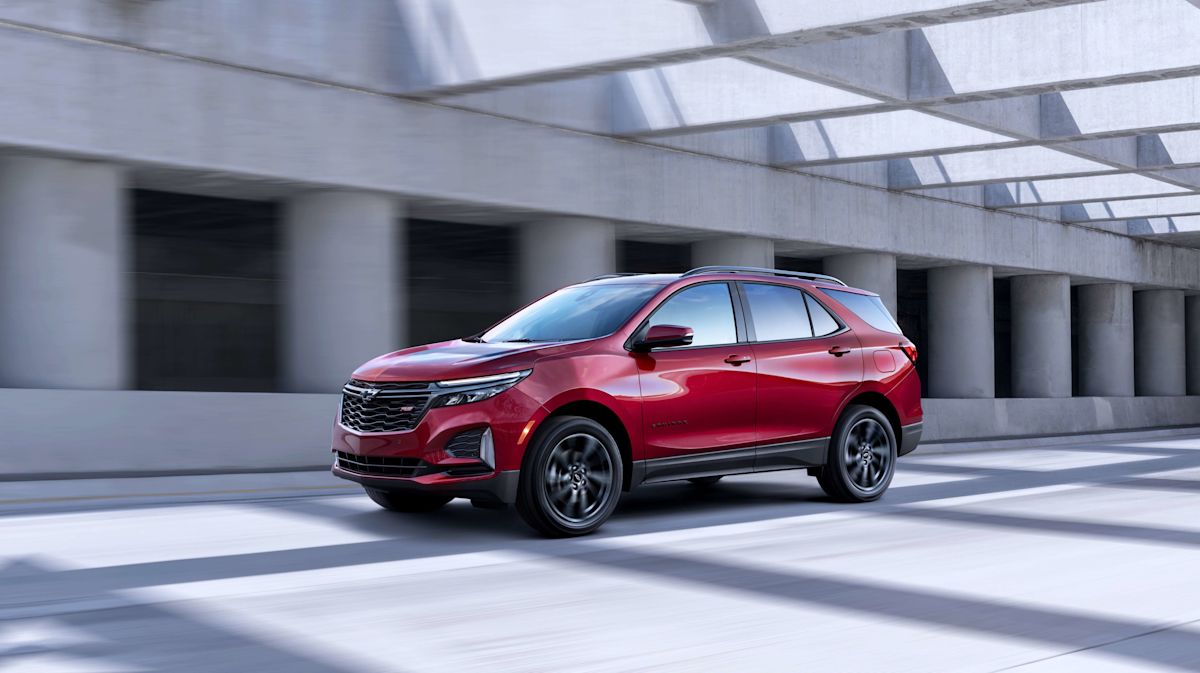 a red 2022 Chevrolet Equinox RS driving on a road