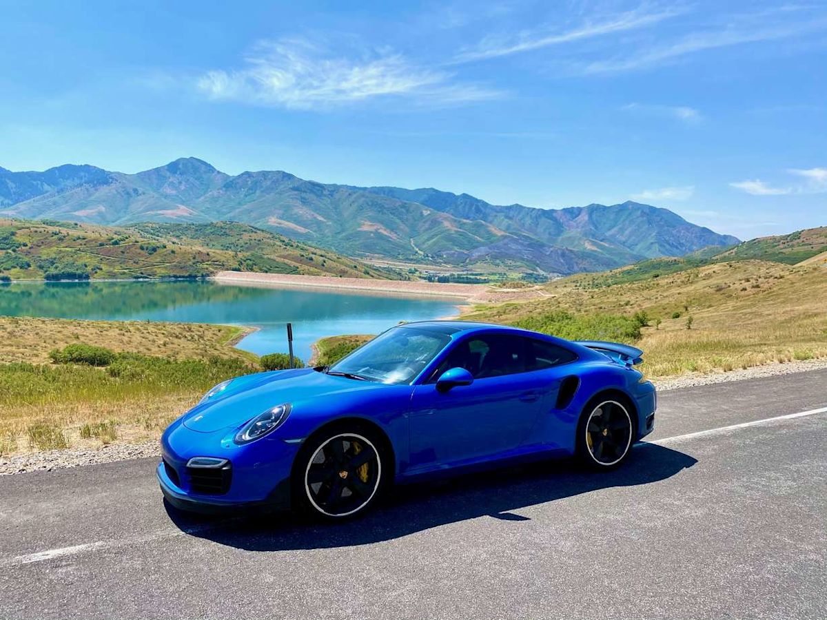A Porsche 911 Turbo S driving on an open road. 